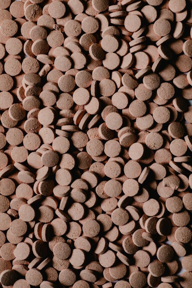 Detailed close-up of numerous brown round pills creating a textured surface.